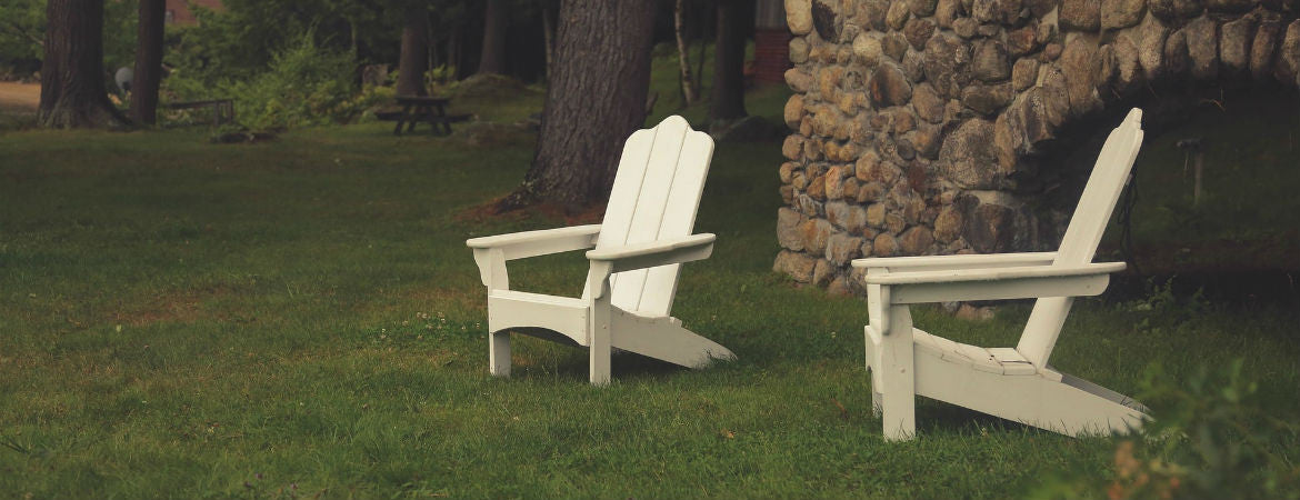 two white chairs by an outdoor fireplace